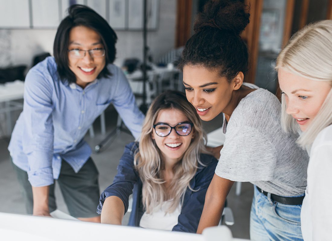 Contact - Group of Female Professionals Gather Together at a Computer to Review Information in an Office